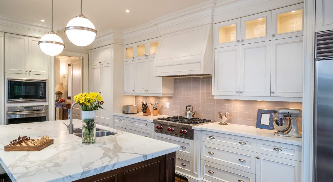 Kitchen with white cabinets and granite countertop.